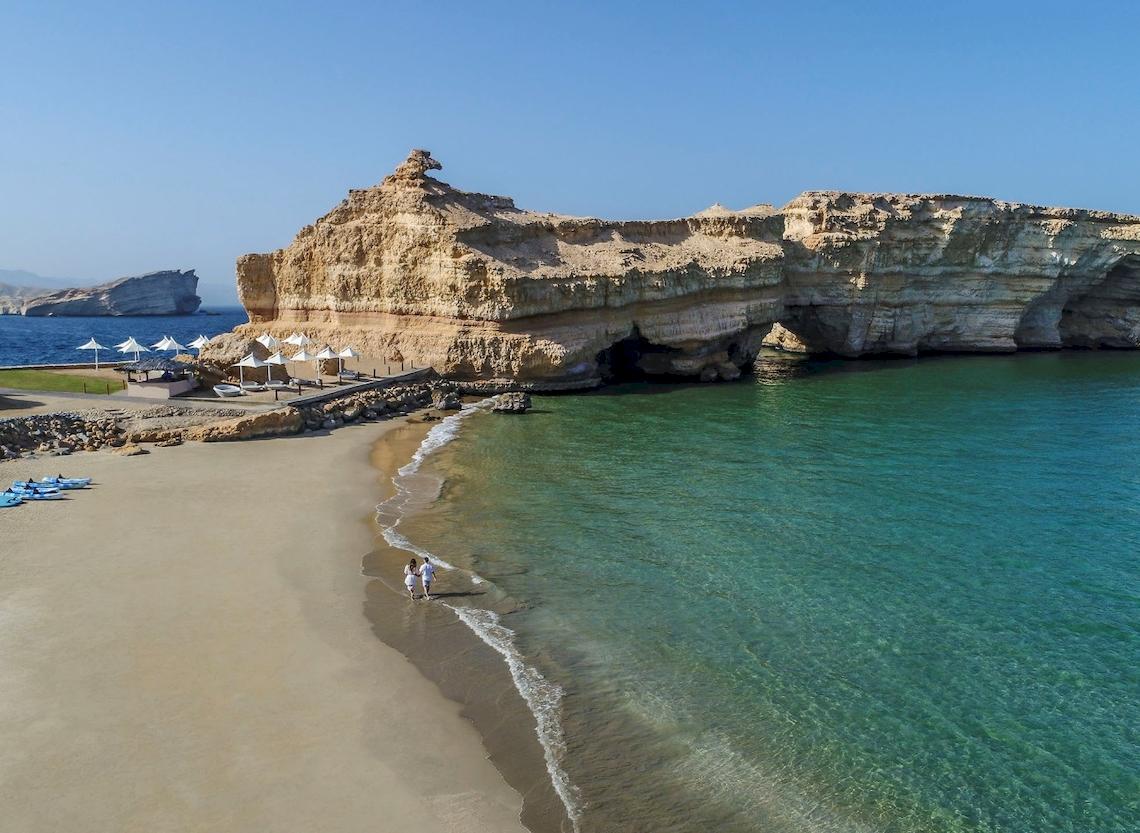 Luftaufnahme eines Strandes mit Sand, Felsen und Wasser am Shangri-La Al Husn Resort & Spa