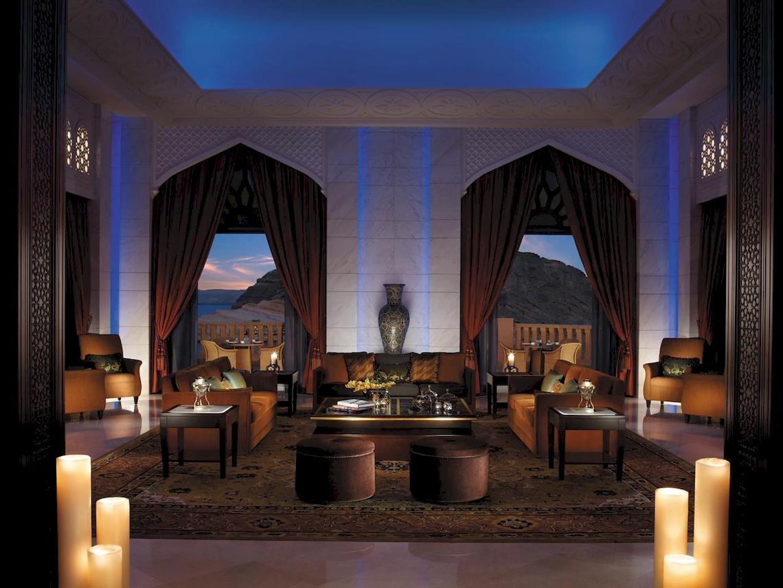 Hotelloungebereich mit Sofas, Tischen und einem großen Vase auf dem Tisch.