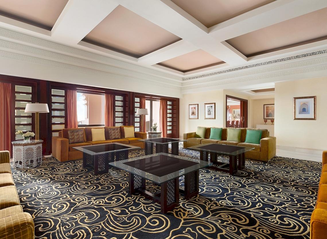 Hotel-Loungebereich im Shangri-La Al Husn Resort & Spa mit Sofas, Tischen und dekorativen Elementen.