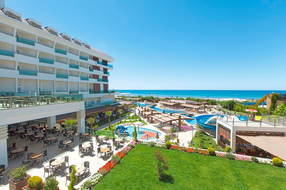 Luftaufnahme des Adalya Ocean Deluxe Hotels mit Blick auf den Swimmingpool und das Meer.