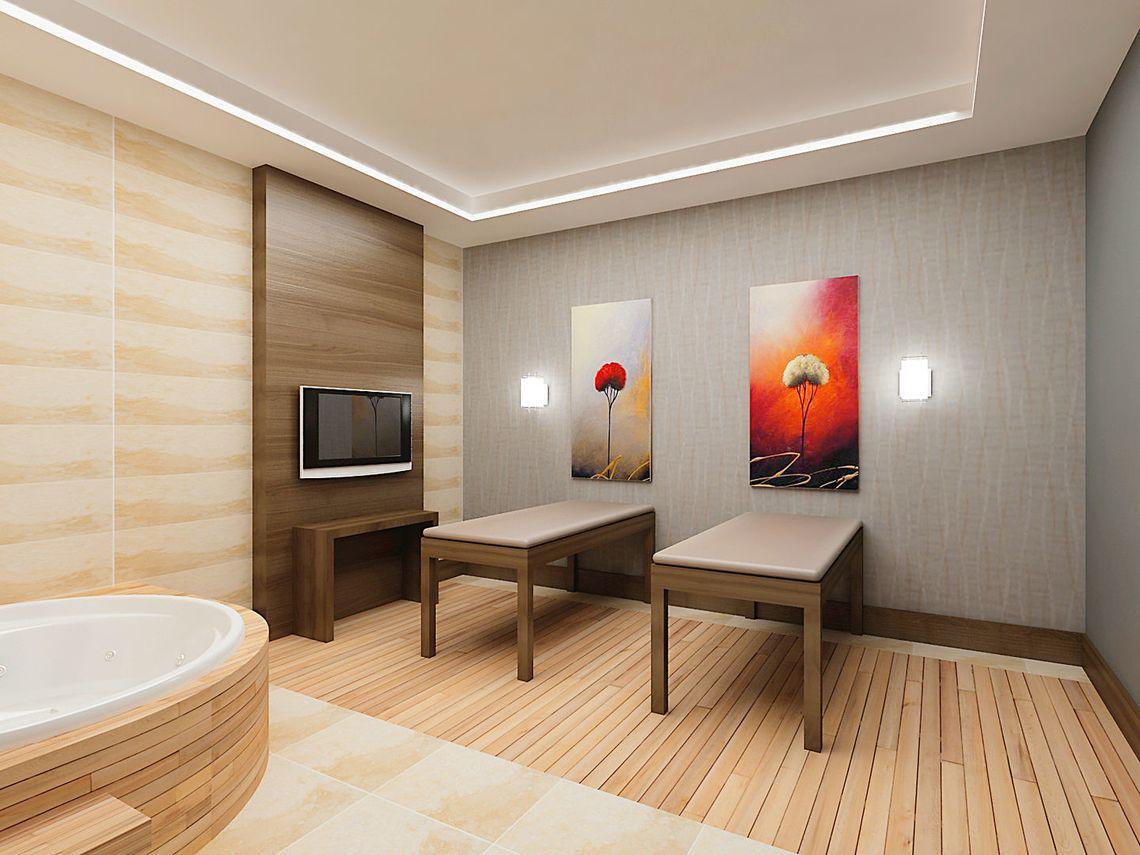 Innenansicht des Behandlungsraums im Adalya Ocean Deluxe Hotel mit Whirlpool, Massagetischen und Kunstwerken an der Wand.