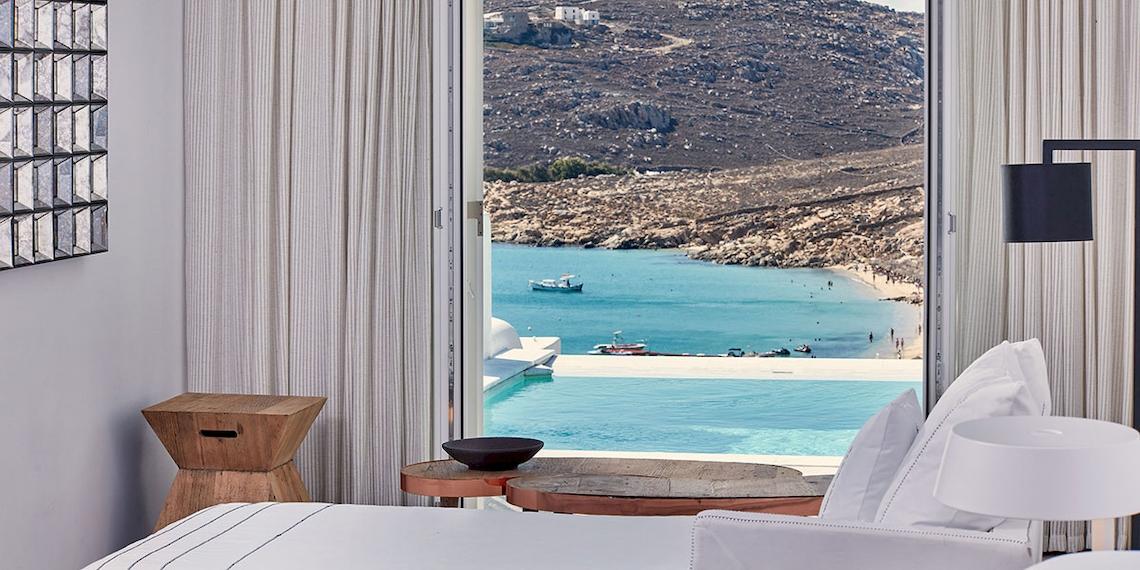 Blick aus einem Hotelzimmer des Royal Myconian Resorts auf einen Pool und das Meer.