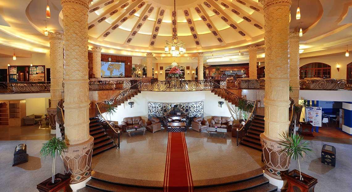 Innenansicht der Lobby des Pickalbatros Jungle Aqua Park Resorts mit großen Säulen und roten Teppich.