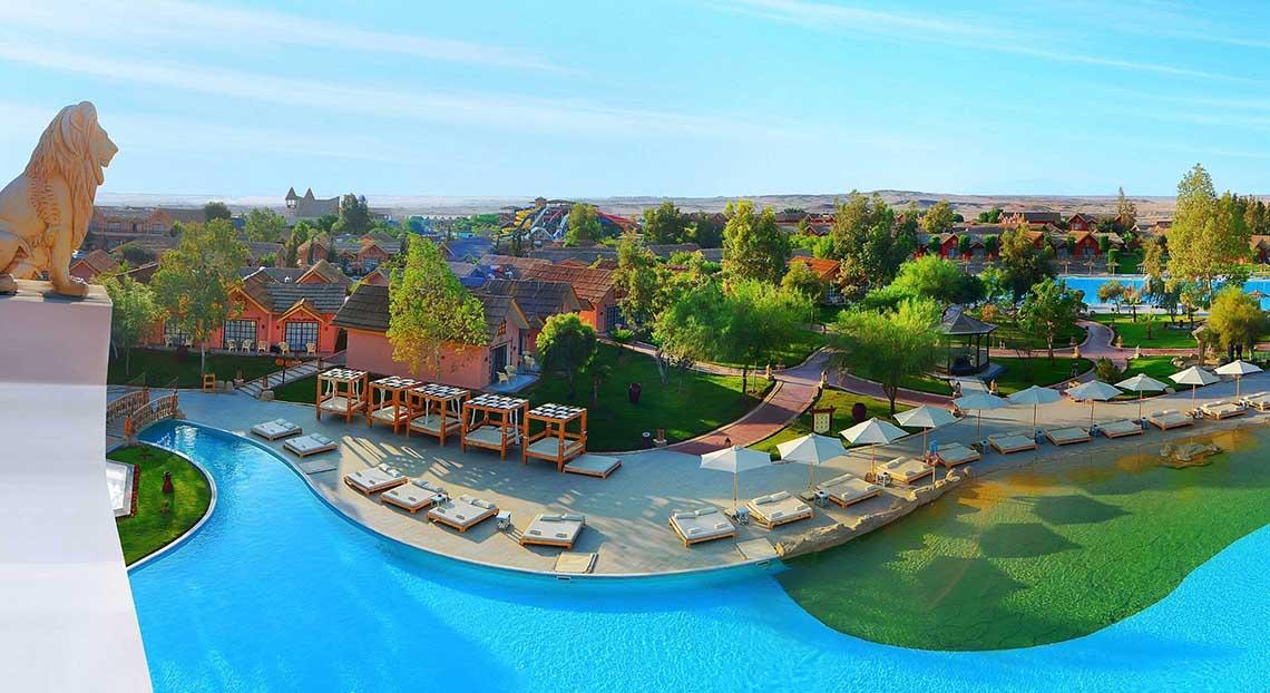 Luftaufnahme des Pickalbatros Jungle Aqua Park Resorts mit Swimmingpool, Liegestühlen und Sonnenschirmen.