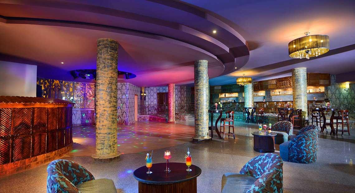 Loungebereich im Pickalbatros Jungle Aqua Park Resort mit bunten Lichtern und modernen Möbeln.