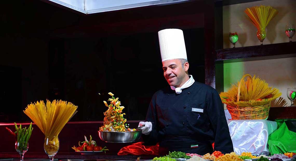 Koch beim Pickalbatros Jungle Aqua Park Resort serviert Gemüse auf einem Buffet.