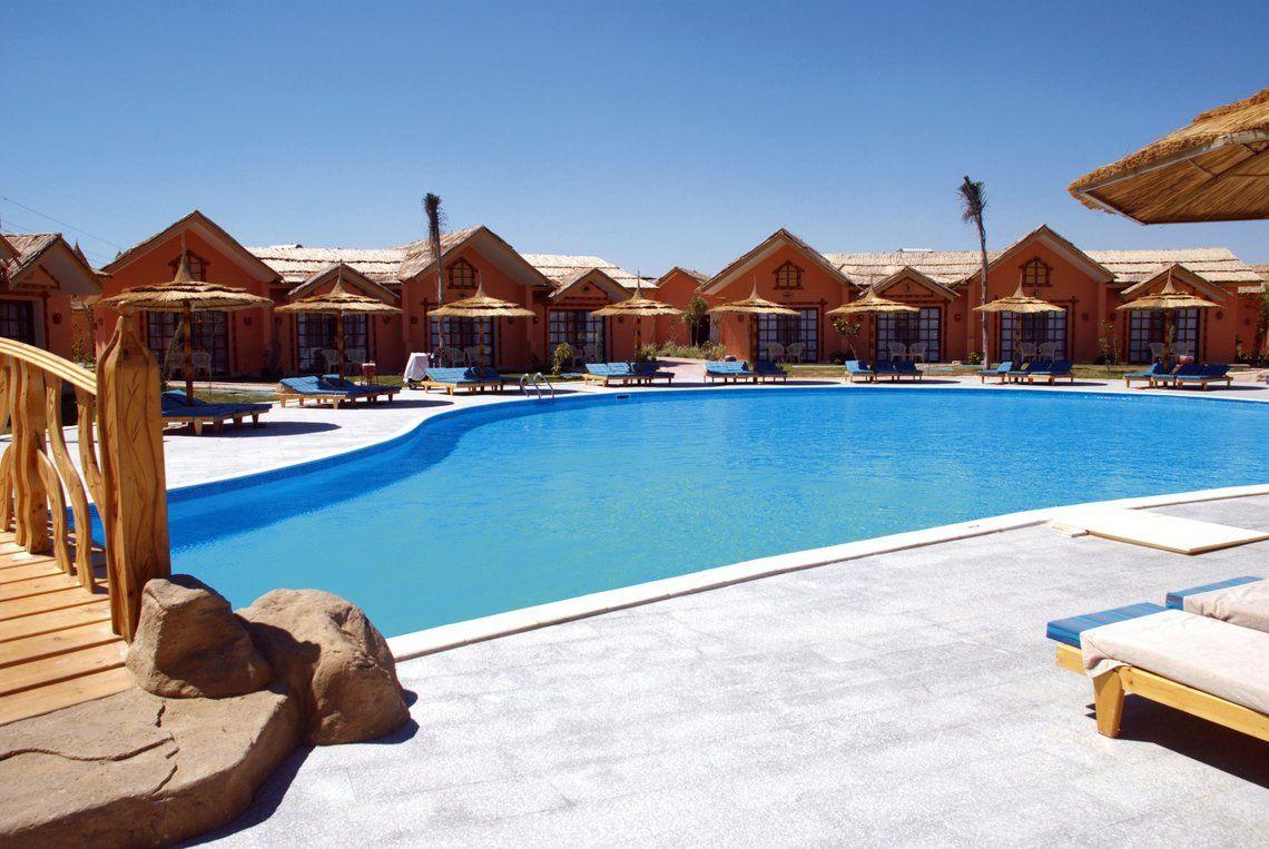 Der Swimmingpool des Pickalbatros Jungle Aqua Park Resorts mit umliegenden Sonnenliegen und Strohdächern.