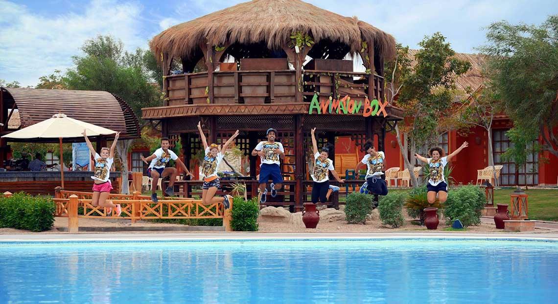 Gruppe von Menschen springt vor einem Pavillon im Pickalbatros Jungle Aqua Park Resort