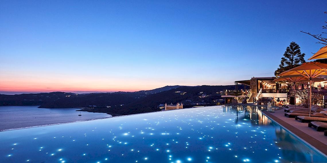 Infinity-Pool des Myconian Utopia Resorts bei Nacht mit Blick auf das Meer und die Berge