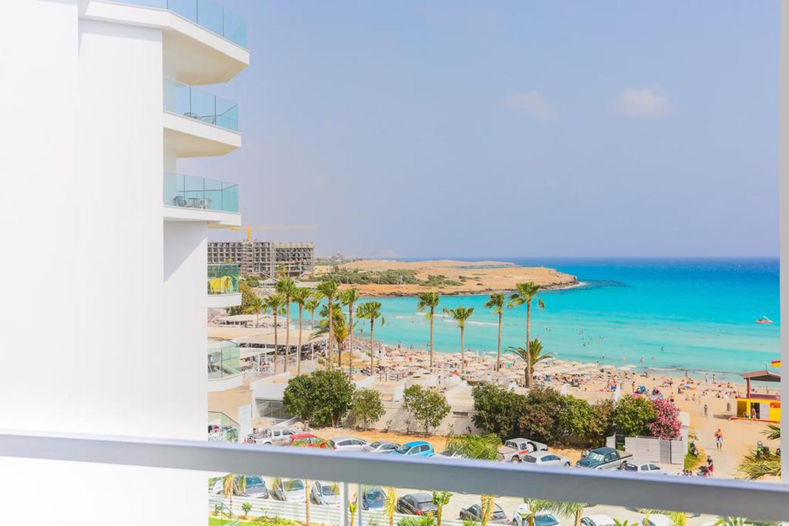 Aussicht von der Terrasse des Vassos Nissi Plage Hotels auf den Strand und das Meer.