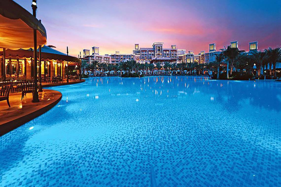 Der Außenpool des Jumeirah Dar Al Masyaf Hotels bei Sonnenuntergang