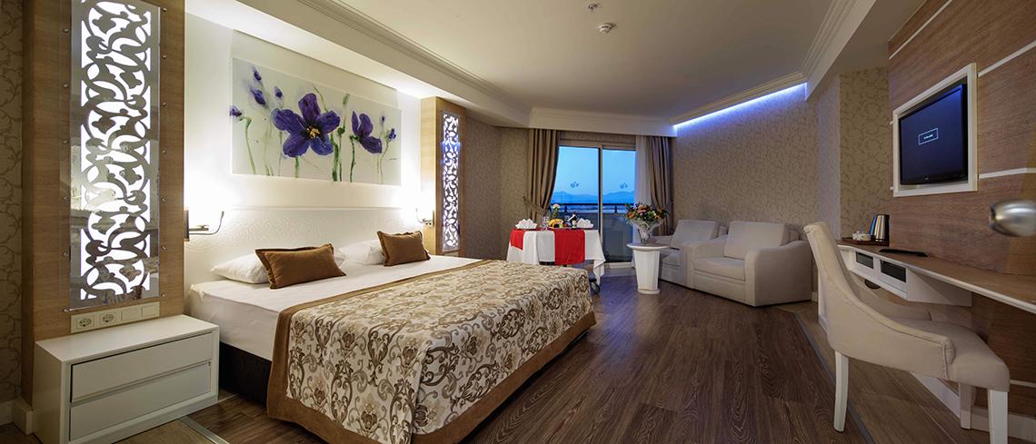 Luxuriöses Hotelzimmer im Crystal Sunset Luxury Resort & Spa mit Doppelbett, Dekor und moderner Einrichtung.
