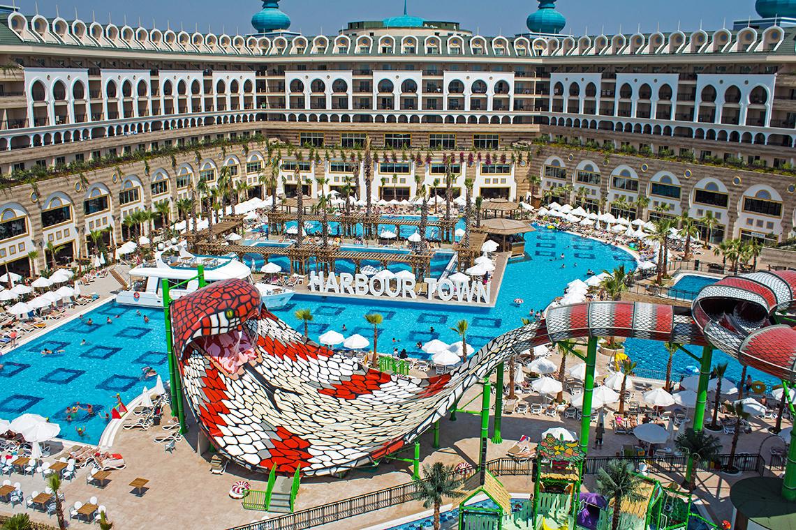 Luftaufnahme des Crystal Sunset Luxury Resort & Spa mit großen Swimmingpools und Wasserrutschen.