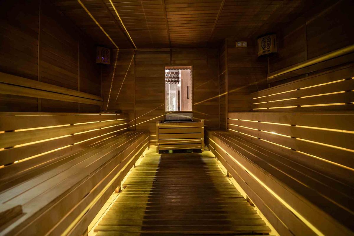 Innenansicht der Sauna im Sidemarin Kirman Premium mit Holzbänken und beleuchteten Wegen.