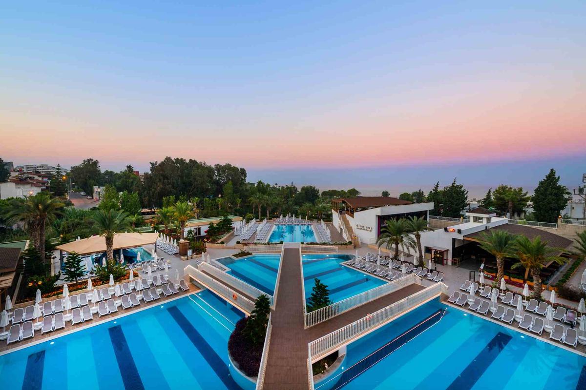 Luftaufnahme des Sidemarin Kirman Premium Hotels mit Swimmingpools, Liegestühlen und Bäumen.