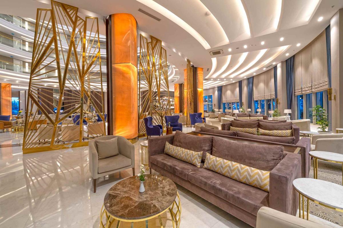 Lobby des Sidemarin Kirman Premium Hotels mit goldenen Strukturen und blauen Vorhängen.
