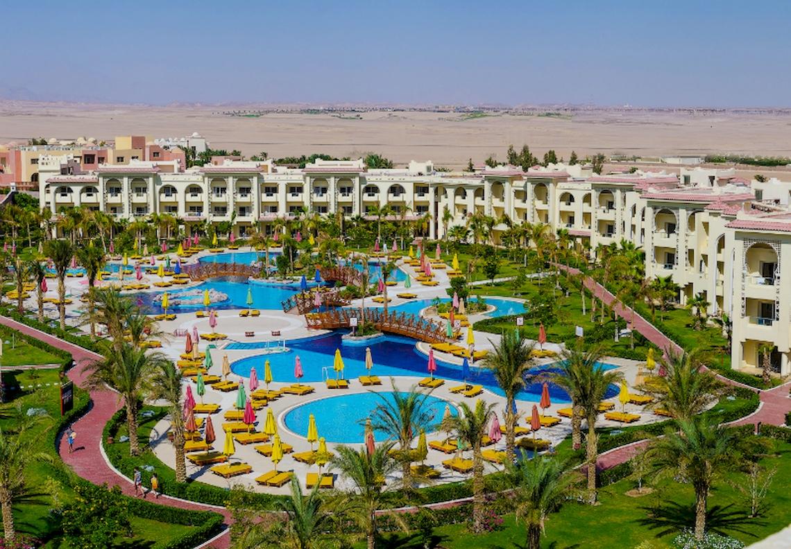 Luftaufnahme des Serenity Alma Heights Resorts mit mehreren Swimmingpools, Liegestühlen und Sonnenschirmen.