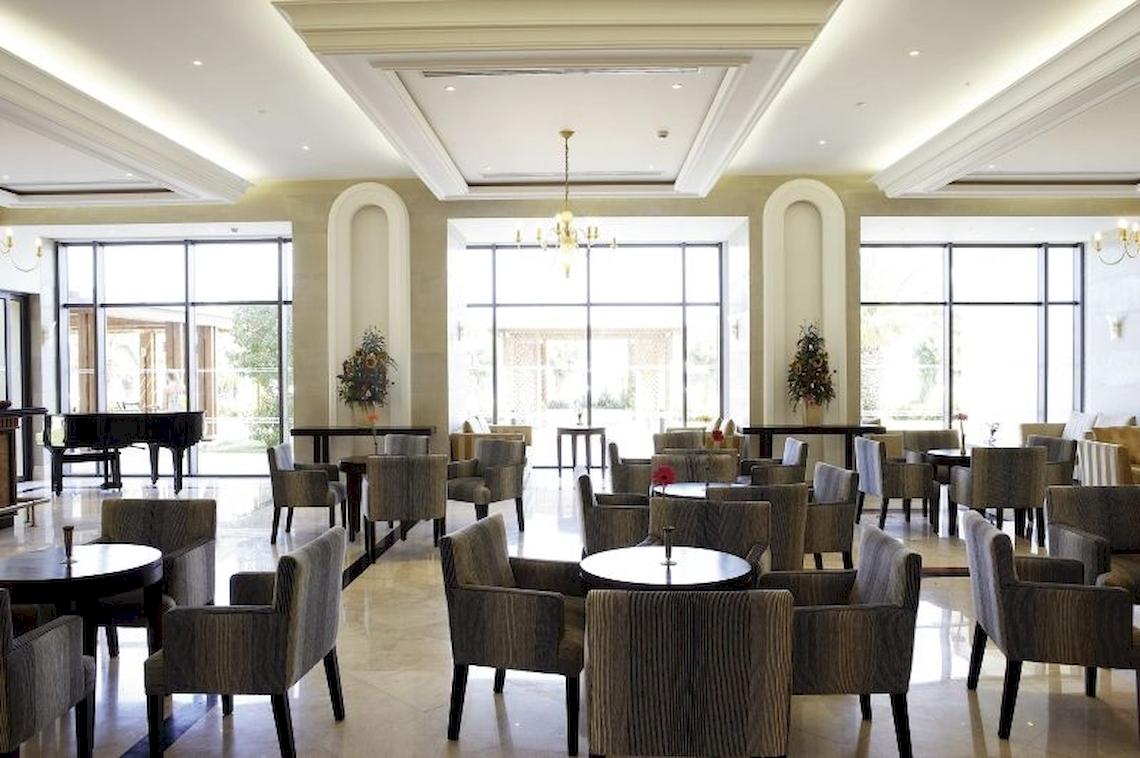 Lobby des Electra Palace Rhodes Hotels mit vielen Stühlen, Tischen und einem Klavier.