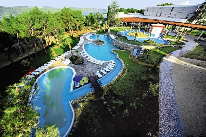 Luftaufnahme des Poolbereichs des Niko Hotels mit mehreren Swimmingpools, Liegestühlen und Sonnenschirmen.