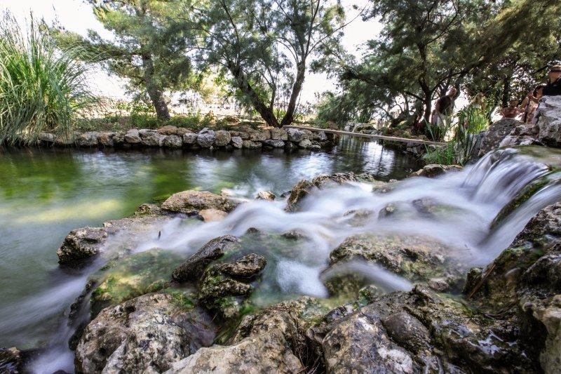 Ein Wasserfall fließt über Felsen in einem waldreichen Gebiet nahe dem Niko Hotel.