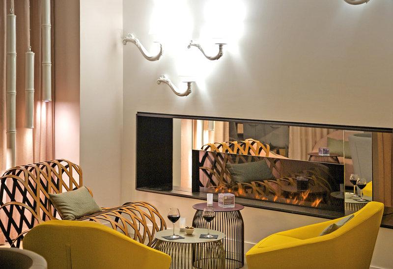 Hotellounge im Mercure Paris Montmartre Sacré-Coeur mit gelben Sesseln, Kamin und Dekor