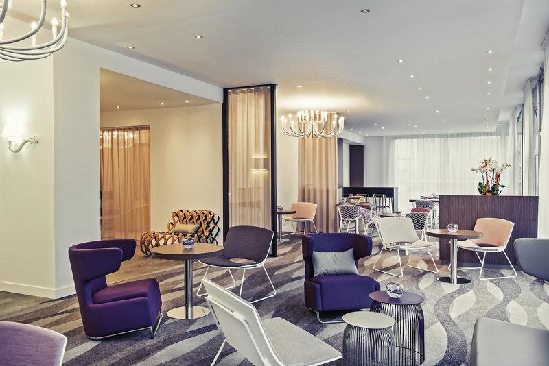 Lobbybereich des Mercure Paris Montmartre Sacré-Coeur Hotel mit verschiedenen Möbeln und Dekor.