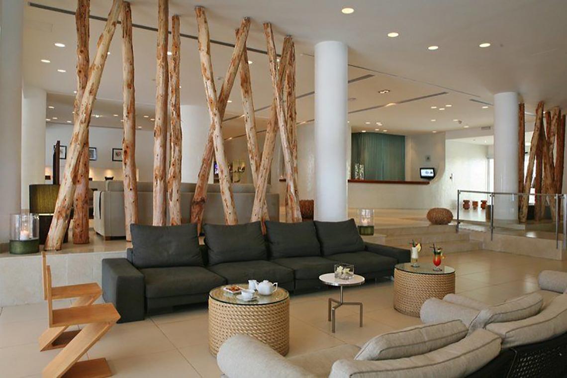 Lobby des Napa Mermaid Hotel & Suites mit großen schwarzen Sofas und rustikalen Holzelementen.