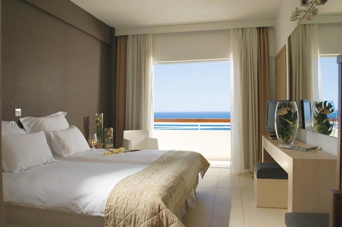 Zimmer im Napa Mermaid Hotel & Suites mit Blick auf das Meer und einen Balkon.