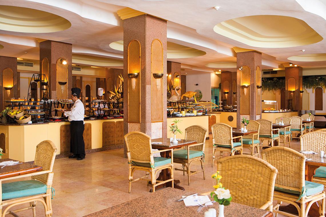 Ein Speisesaal im Grand Hotel Hurghada mit einem Buffet und einem Tisch.