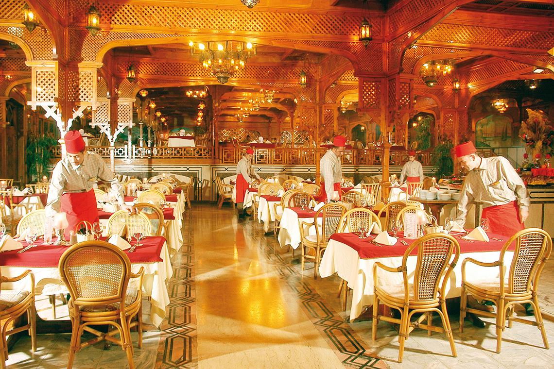Restaurantbereich im Grand Hotel Hurghada mit gedeckten Tischen und Kellnern in traditioneller Kleidung