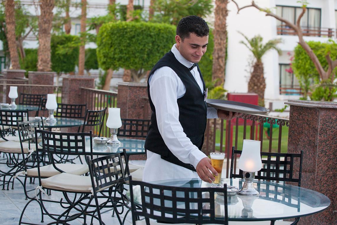 Ein Hotelmitarbeiter serviert ein Bier auf der Terrasse des Grand Hotel Hurghada.