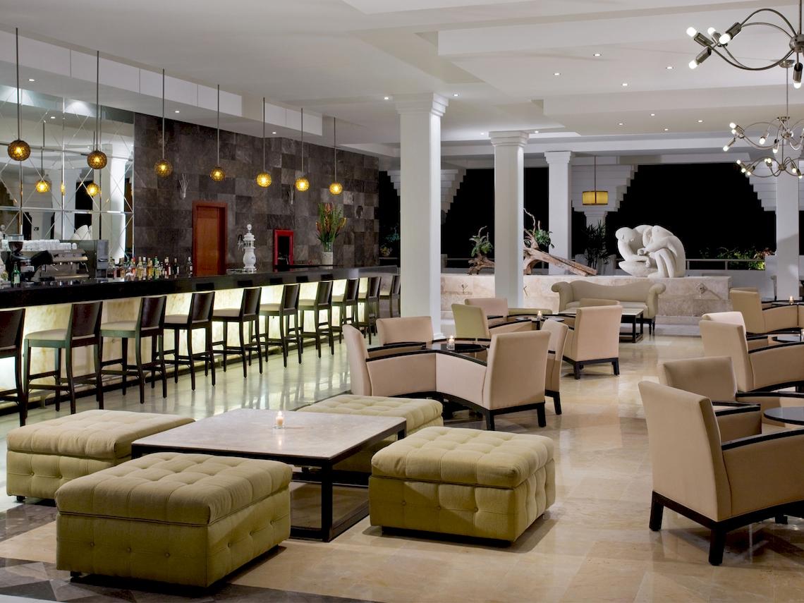 Loungebereich im Grand Sunset Princess All Suites Resort Hotel mit Bar, Sesseln und Tischen.