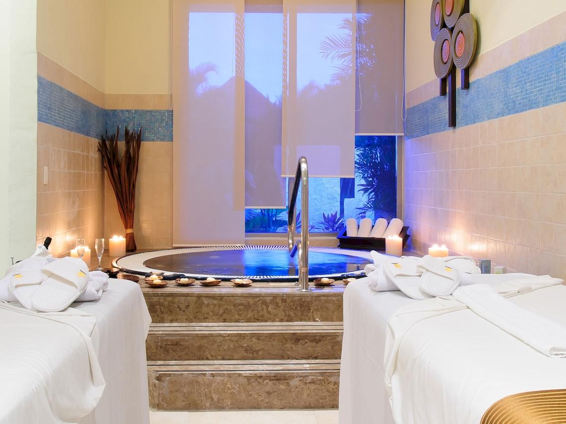 Spa-Bereich im Grand Sunset Princess All Suites Resort mit Whirlpool, Kerzen und Liegen.