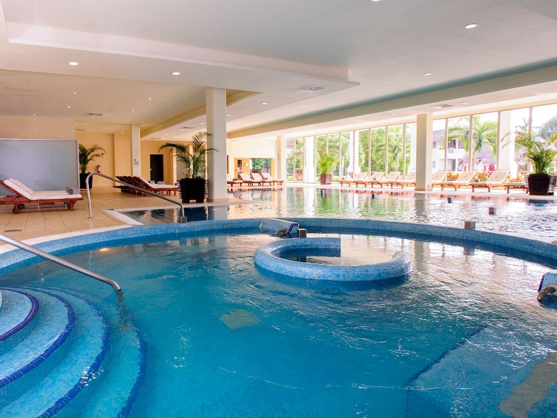 Außenpool des Grand Sunset Princess All Suites Resorts mit Loungeliegen und Pflanzen