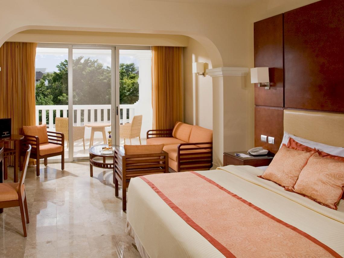 Suite Zimmer im Grand Sunset Princess All Suites Resort mit Balkon und modernen Möbeln.