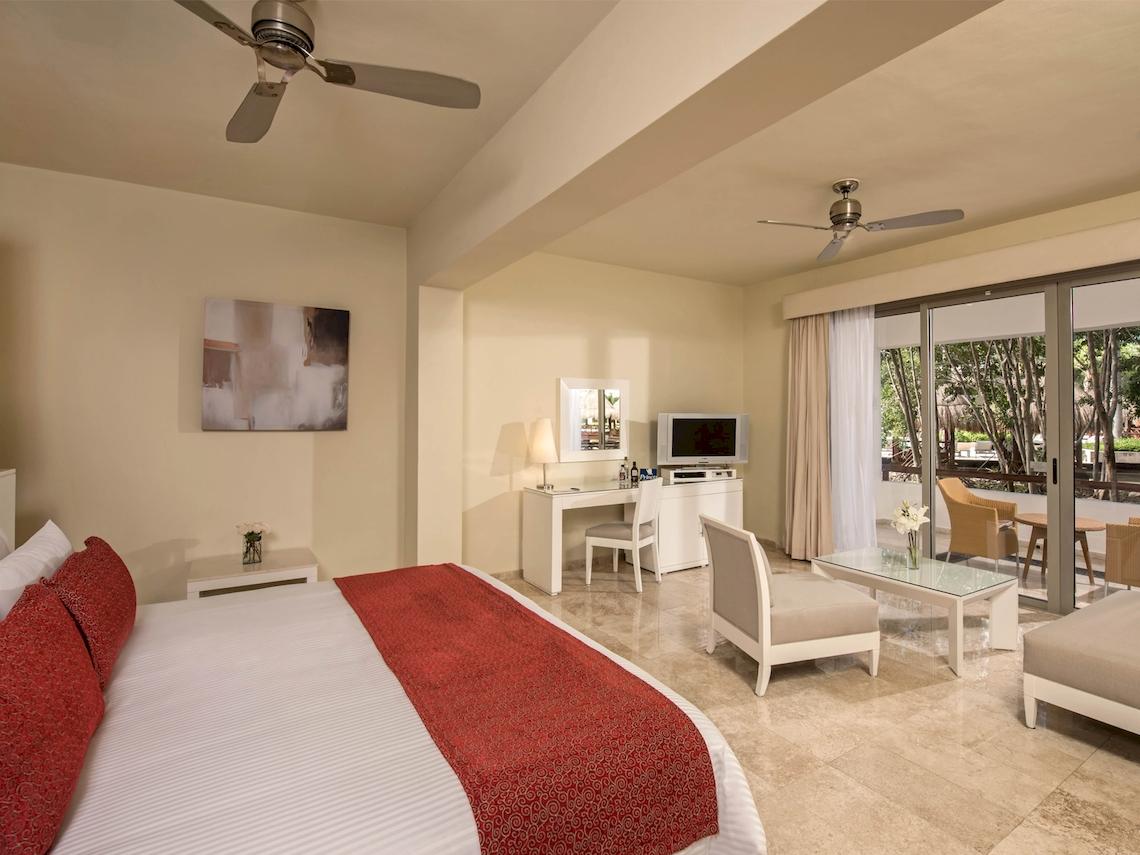 Schlafzimmer im Grand Sunset Princess All Suites Resort mit Bett, Schreibtisch und Terrasse