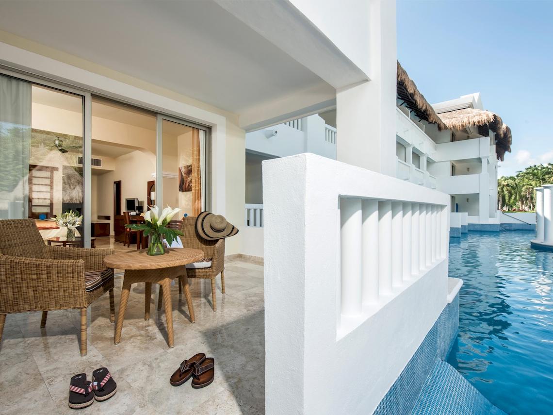 Terrasse des Grand Sunset Princess All Suites Resorts mit Tisch, Stühlen und Pool