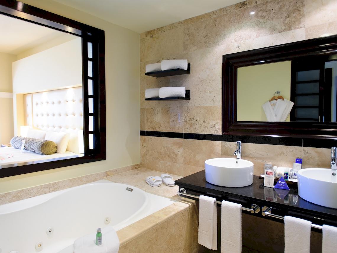 Badezimmer mit Badewanne, Spiegel und Doppelwaschbecken im Grand Sunset Princess All Suites Resort.