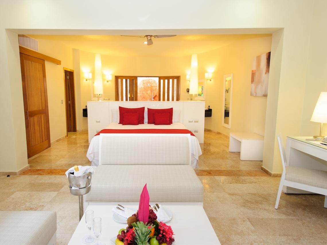 Ein modernes Hotelzimmer mit einem Bett, roten Kissen und einem luxuriösen Ambiente.