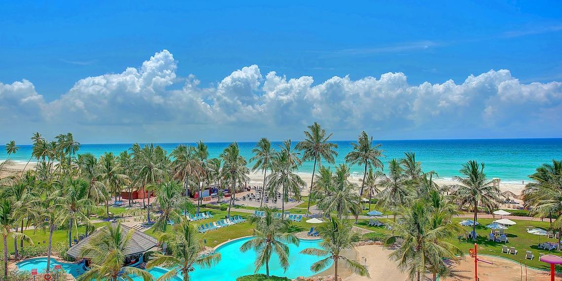 Luftaufnahme des Crowne Plaza Resort Salalah mit Pool, Strand und Palmen