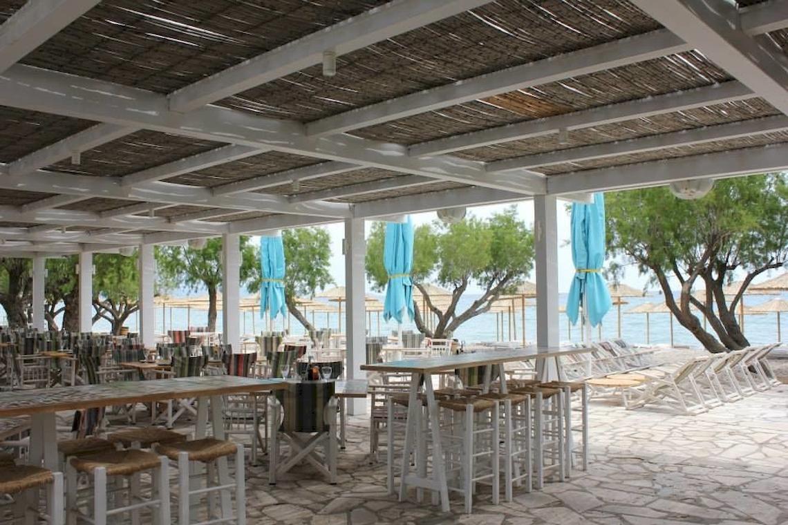 Überdachte Terrasse im Doryssa Seaside Resort mit Blick auf den Strand und das Meer.