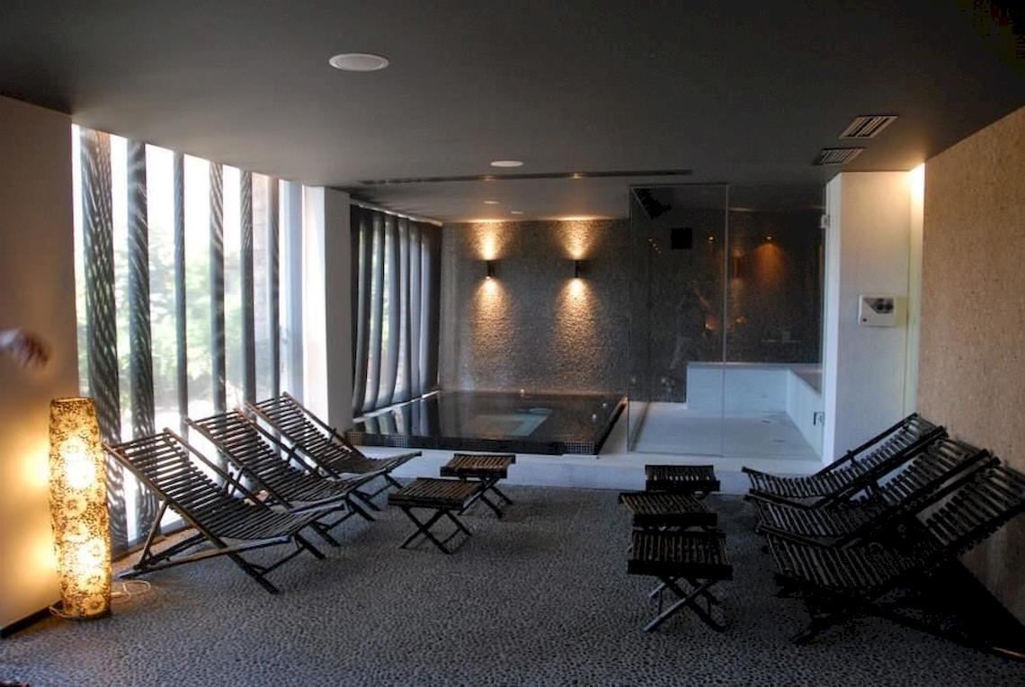 Innenbereich des Doryssa Seaside Resort mit Lounge-Stuhlreihen und Whirlpool.