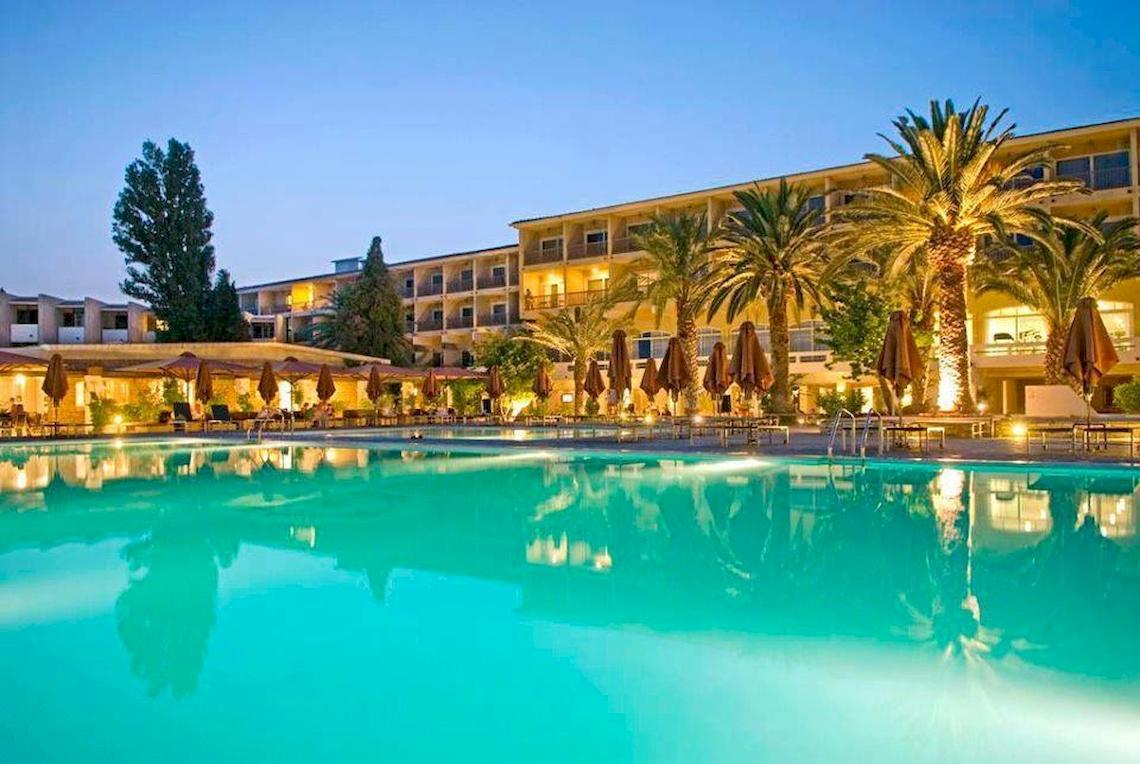 Doryssa Seaside Resort mit Pool und Palmen bei Nacht