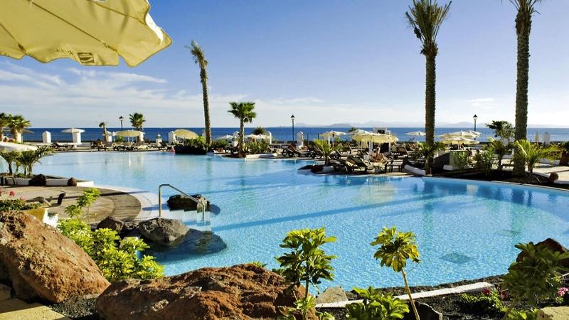 Außenpool des Gran Castillo Tagoro Family & Fun Hotels mit vielen Sonnenliegen und Palmen