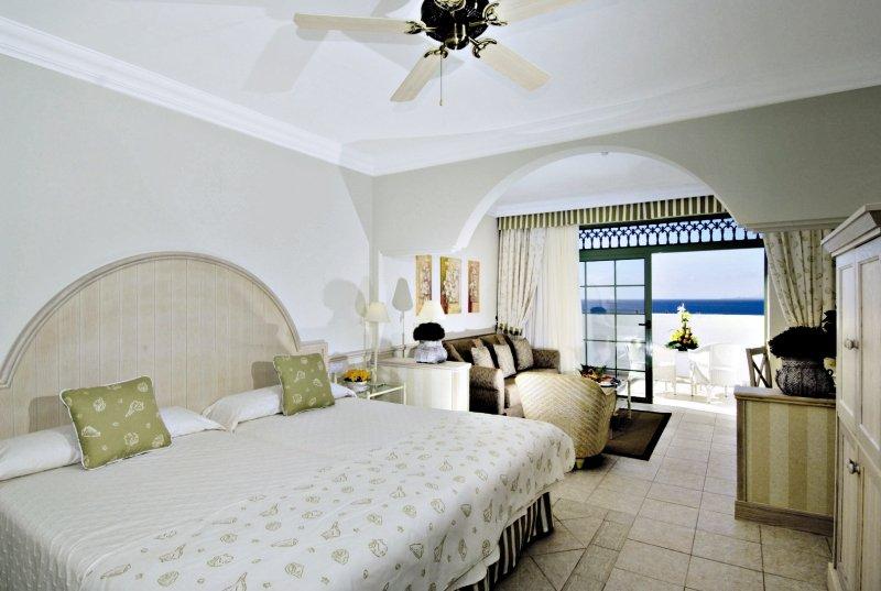 Schlafzimmer im Gran Castillo Tagoro Family & Fun Hotel mit großem Bett und Meerblick.
