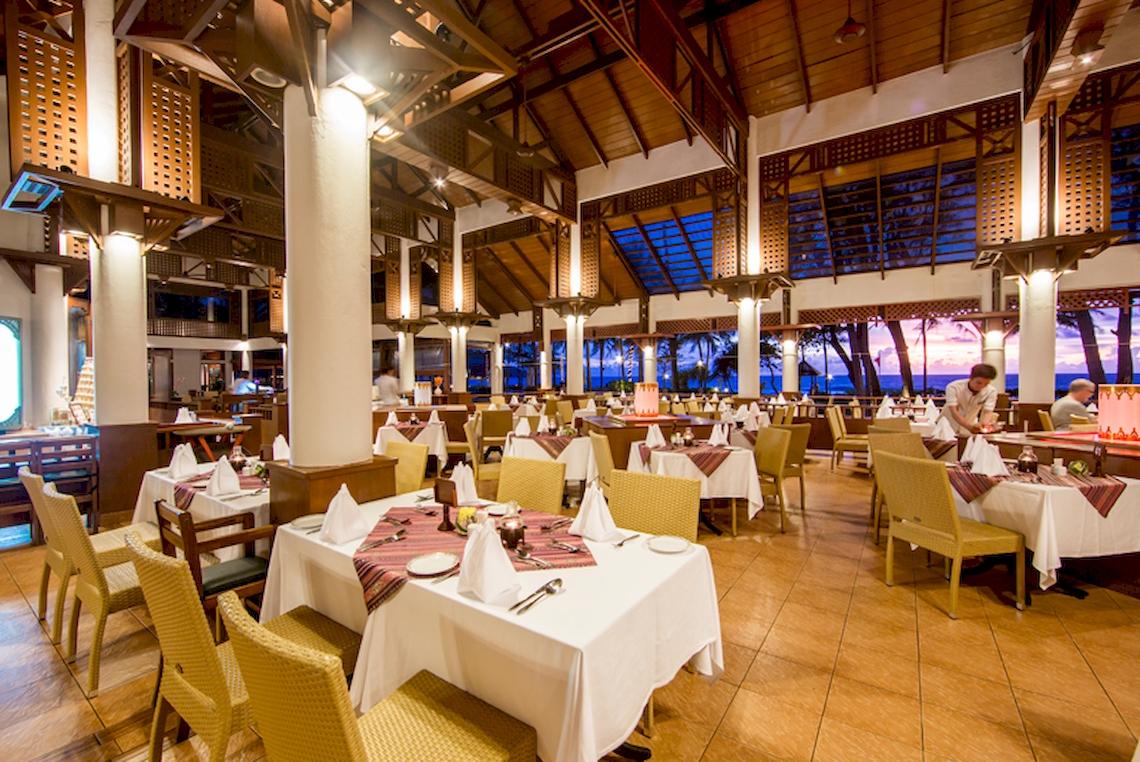 Innenansicht des Restaurants im Katathani Phuket Beach Resort mit gedeckten Tischen und Stühlen.