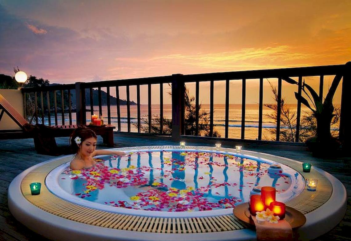 Frau im Whirlpool auf der Terrasse des Katathani Phuket Beach Resorts am Abend.