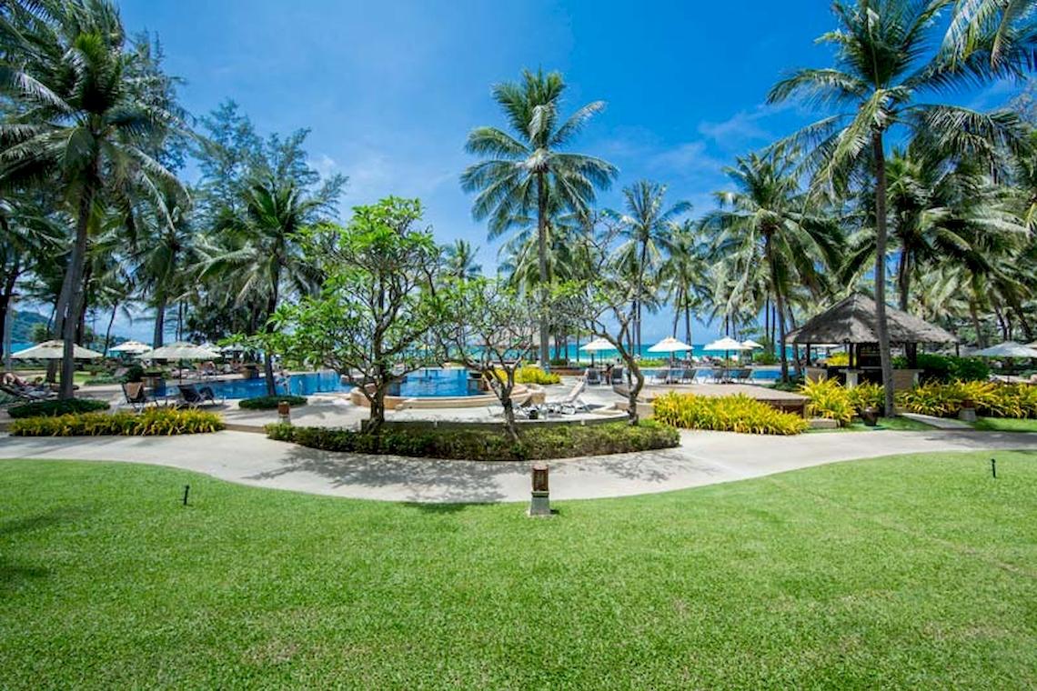 Außenbereich des Katathani Phuket Beach Resorts mit Pool und Palmen