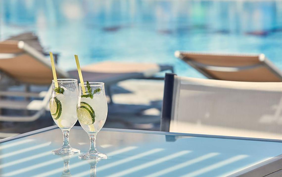 Zwei Gläser mit Getränken auf einem Tisch am Pool des Atlantica Mikri Poli Kos Hotels