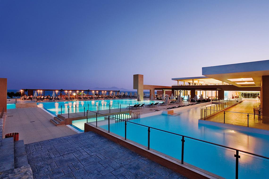 Außenpool des Atlantica Mikri Poli Kos Hotels bei Nacht mit Loungeliegen und Blick auf das Meer